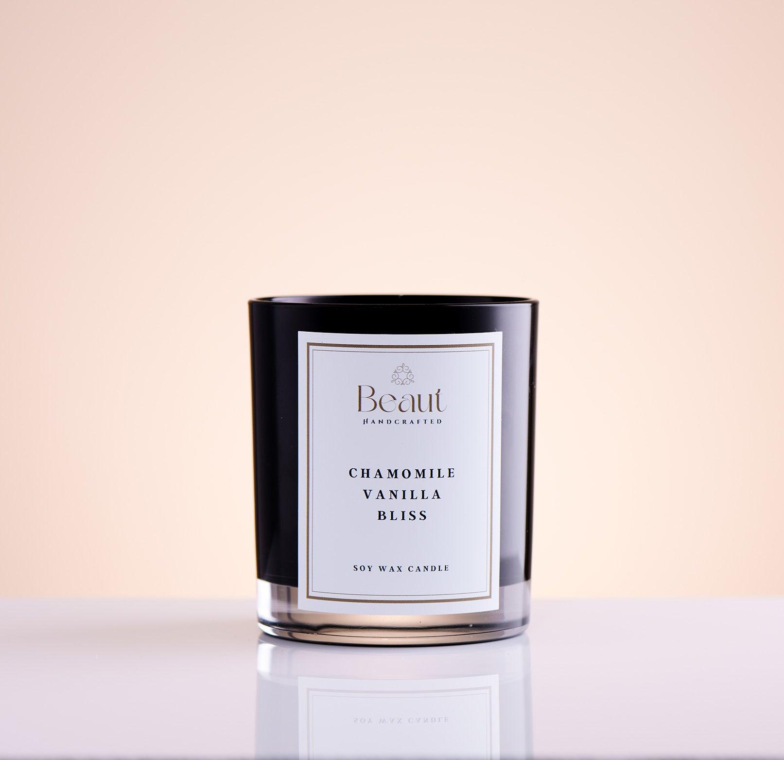 candle in black glass container photographed in angle to show full beauty of the design, wooded wick and overal candle look